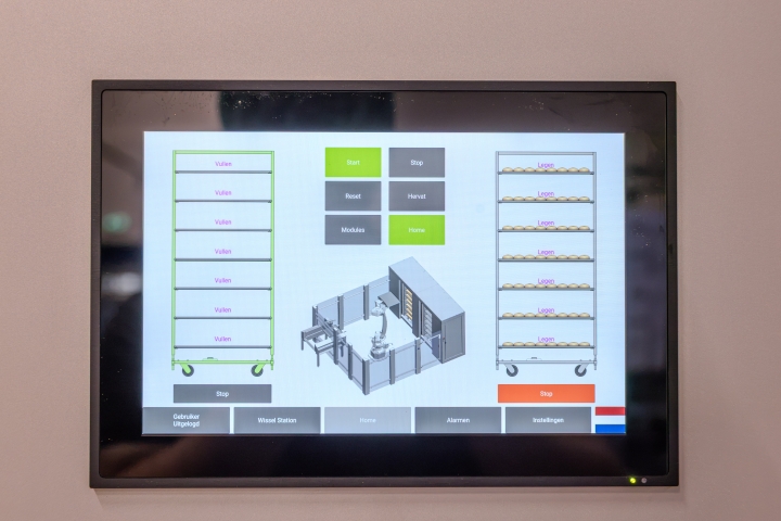 Automatisch ontladen van bakplaten in een industriële productielijn.